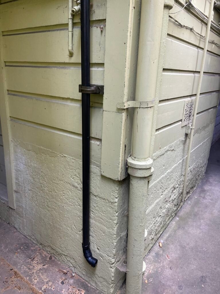 Downspout running down the corner of a house exterior in San Francisco