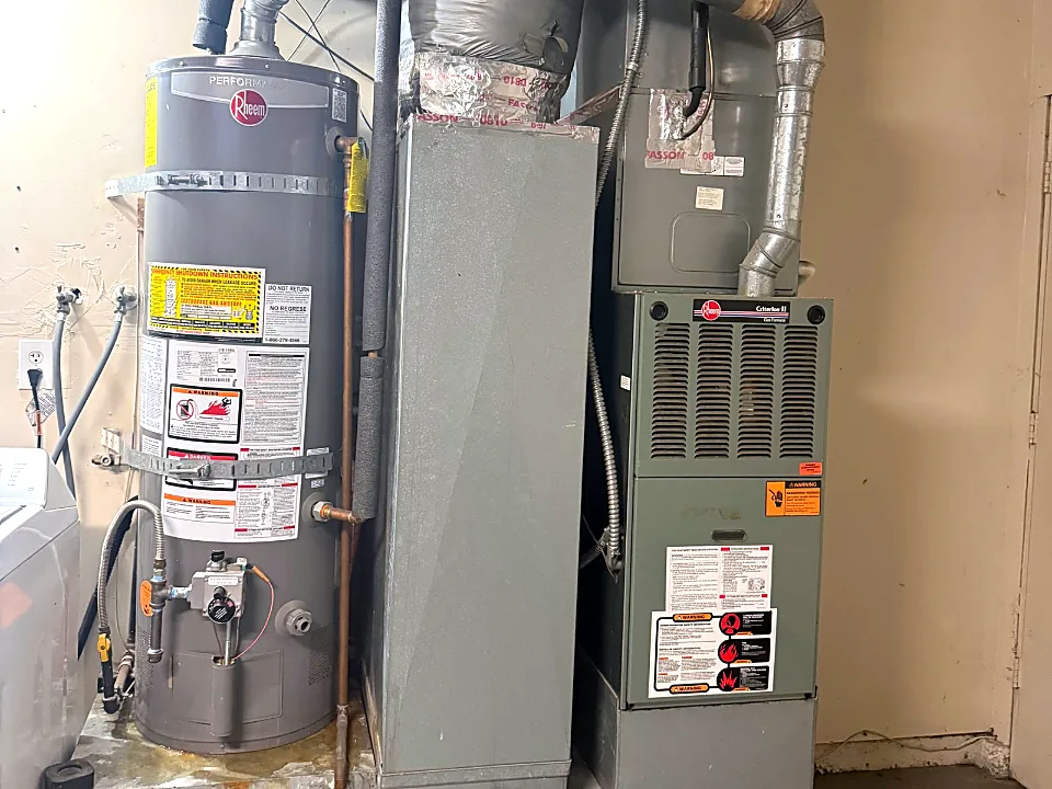 Rheem gas water heater with earthquake straps installed next to a furnace in a San Francisco utility room